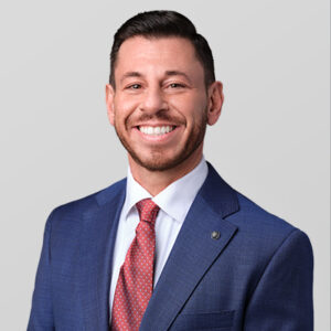 Dennis Shlionsky wearing a blue jacket and red tie.